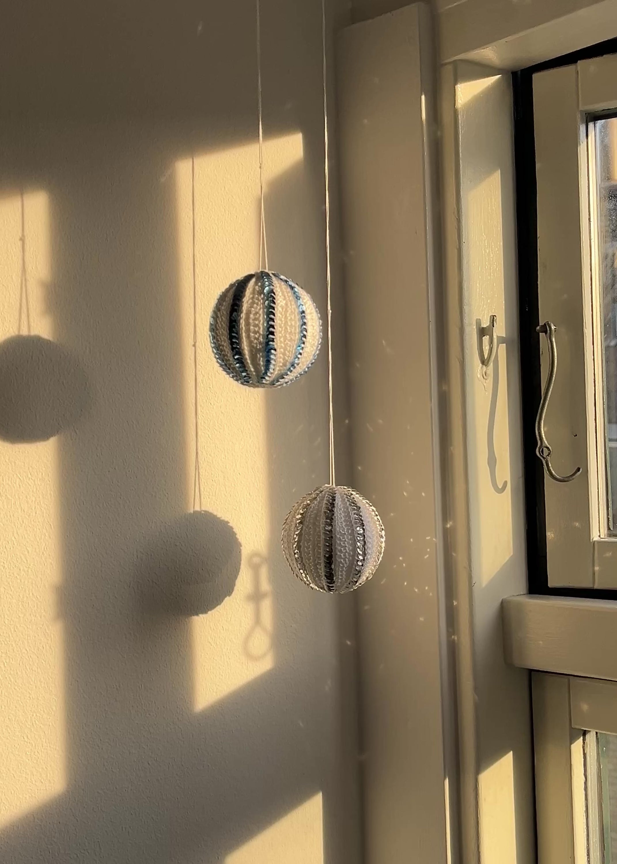 hjemmelavet hæklet julekugle med pailletter der glitrer i solen